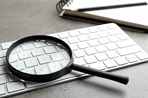 magnifying glass on keyboard to represent Ahrefs Keyword research