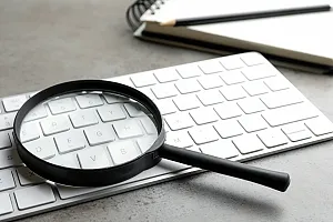 magnifying glass on keyboard to represent Ahrefs Keyword research