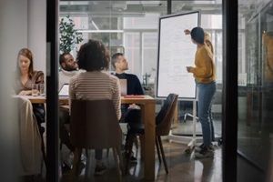 project manager makes a presentation for a young diverse creative team in meeting room in an agency